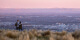 Image taken at dusk of two people looking down from the Port Hills over Christchurch