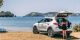 Image of a female looking in the boot of a Hyundai Santa Fe rental car parked next to the sea