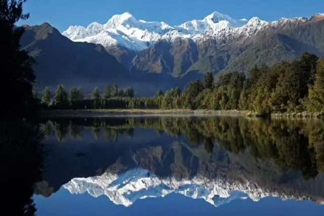 Image of the Southern Alps and Mount Cook reflecting in the crystal clear waters of Lake Matheson