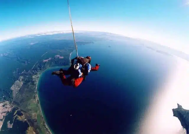 Image of a tandem skydive over Lake Taupo, New Zealand /></noscript><a class=