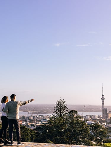 Image of the Auckland city skyline taken at sunset with the lights shining on all the buildings and in the port