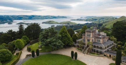 Historic castle with lush gardens and a scenic coastal view