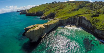 Aerial view of Tunnel Beach with cliffs and turquoise water