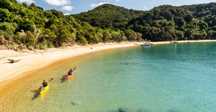 Two kayakers paddling on a turquoise bay