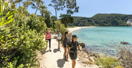 Hikers on a coastal trail by a clear blue sea