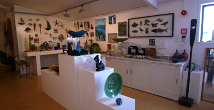 Interior of an art gallery with various pieces displayed on walls and shelves