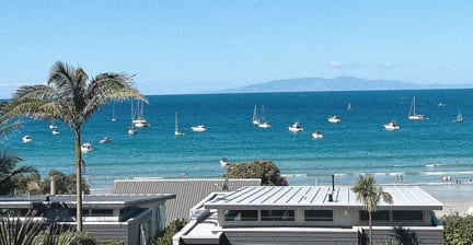 Coastal view with boats on the ocean and modern buildings in the foreground