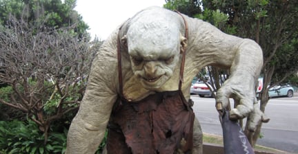 A statue of a large troll character from The Lord of the Rings, reaching forward with one arm