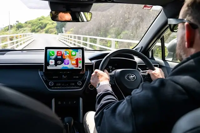 Car interior shot of a person driving a GO Rentals hybrid car